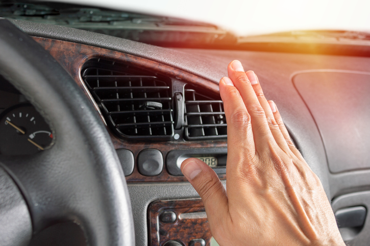 Closeup of hand driver man checking adjusting air from conditioning the cooling system with flow of cold air in car.