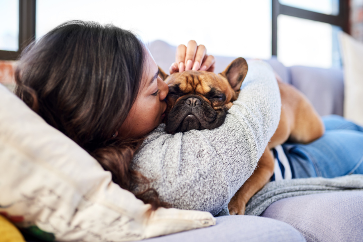 Shot of a young woman relaxing with her dog at home